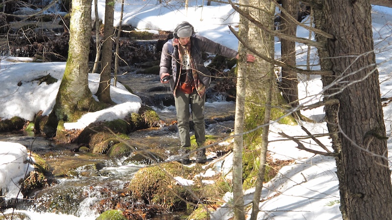 photo of ben walking in the woods with a microphone and a portable recorder.